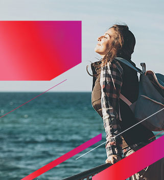 #PraCegoVer Texto: SEGURO VIAGEM BRADESCO. Tranquilidade para aproveitar as férias. Imagem: moça está em pé, com a cabeça erguida e sentindo o vento no rosto, debruçada sobre um parapeito com o mar no horizonte.